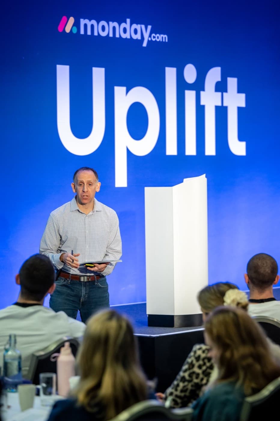 Russell Scherwin on stage, speaking to the room